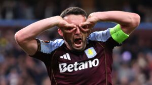 John McGinn celebrating in an Aston Villa kit during a match.